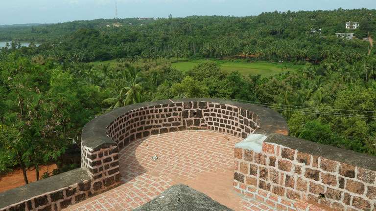 Stone watchtower brick bastion of Chandragiri Fort overlooking green canopies
